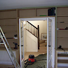<p>cupboards and book shelves built around double doors</p>