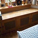 <p>Window seat with decorative grilles to top and doors to allow radiator heat out.</p>